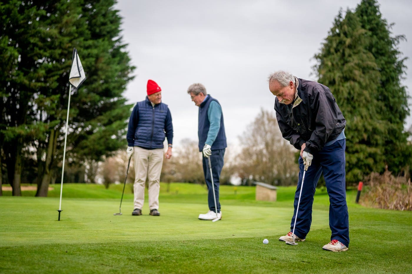 Three golfers on a UK parkland course